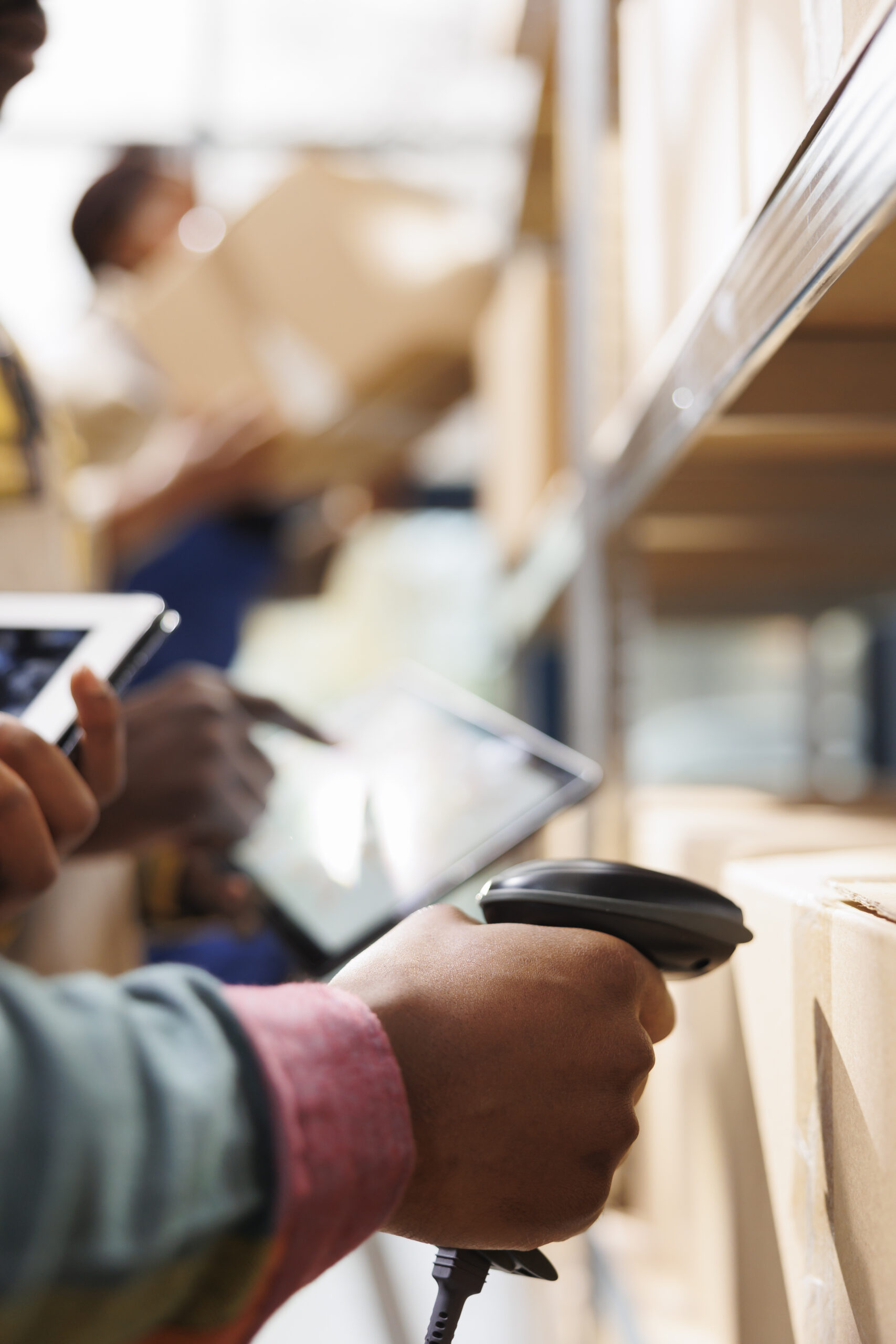 African american distribution warehouse worker arm scanning box code